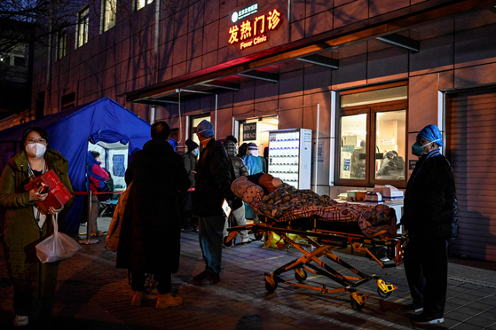 A Covid-19 patient is sent to a hospital in Beijing on Dec. 21. [AFP/YONHAP] 