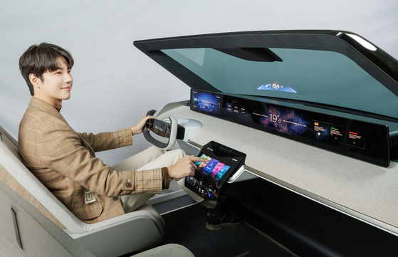 A model shows off a digitalized cockpit featuring LG Display's plastic organic light-emitting diode display. [LG DISPLAY] 