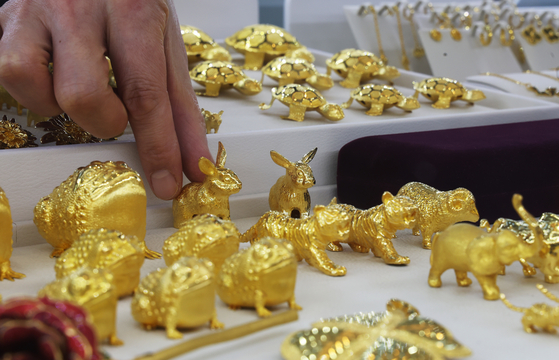 A worker organizes gold ingots at a pawn shop in Jung District, central Seoul, on Wednesday. Gold prices are on the rise due to economic slowdown as gold for February delivery rose 1.1 percent, or $19.90, to settle at $1,846.10 an ounce on the Comex. [YONHAP]