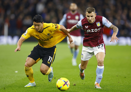 Wolverhampton Wanderers' Hwang Hee-chan in action against Aston Villa's Lucas Digne at Villa Park in Birmingham on Wednesday.  [REUTERS/YONHAP]