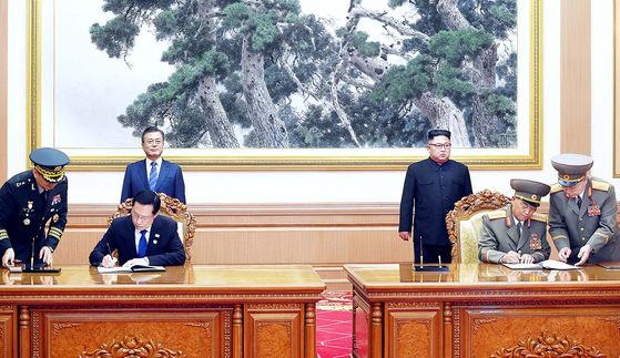 President Moon Jae-in, back row left, and North Korean leader Kim Jong-un, back row right, watch South Korean Defense Minister Song Young-moo and North Korean Minister of the People’s Armed Forces No Kwang-chol sign the Comprehensive Military Agreement after the inter-Korean summit in Pyongyang on Sept. 19, 2018. [JOINT PRESS CORPS]