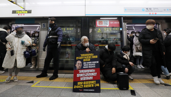 Park Kyoung-seok, head of the Solidarity Against Disability Discrimination, sits at a platform in Hyehwa Station, line No. 4, on Jan. 5, protesting for a bigger budget to protect the rights of people with disabilities. [NEWS1] 
