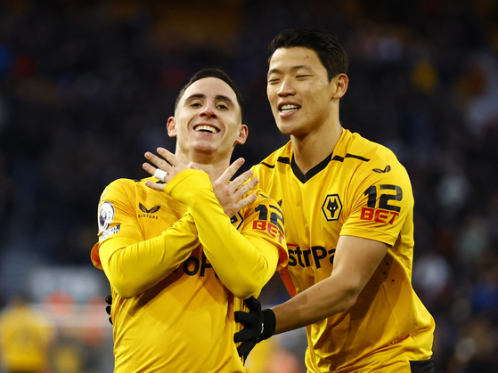 Wolverhampton Wanderers' Daniel Podence, left, celebrates with Hwang Hee-chan after scoring the sole goal in Wolves' 1-0 win over West Ham at Molineux Stadium in Wolverhampton, England on Saturday. Hwang played 73 minutes in the win, Wolves' second in the Premier League since Julen Lopetegui took the helm for the midlands club. Those two wins in four games tie the team's record over the previous 22 matches.  [REUTERS/YONHAP]