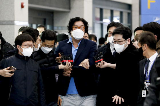 Kim Seong-tae, center, ex-chairman of SBW Group, arrives at Incheon International Airport on Tuesday morning after eight months on the lam. [YONHAP]