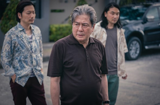 Actor Choi Min-sik, center, as Cha Mu-sik in "Big Bet" [DISNEY+]