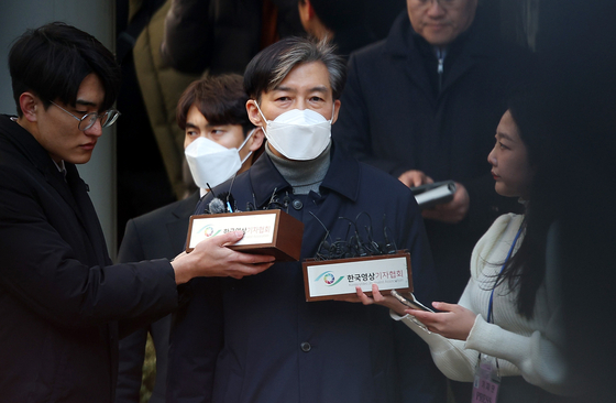 Former Justice Minister Cho Kuk, center, speaks to the press on Friday outside the Seoul Central District Court in Seocho District, southern Seoul, after the court sentenced him to two years in prison. [YONHAP]