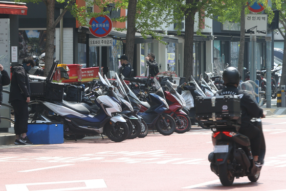 Delivery motorcycles are parked on a street in Yongsan District, central Seoul, on April 18, 2022. [YONHAP]