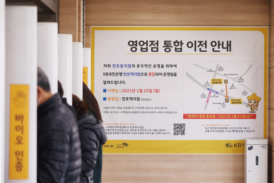 A notice posted in a KB branch in Gangdong District, eastern Seoul, on January 2022 informs customers on the plan to merge with another KB branch nearby. [YONHAP]