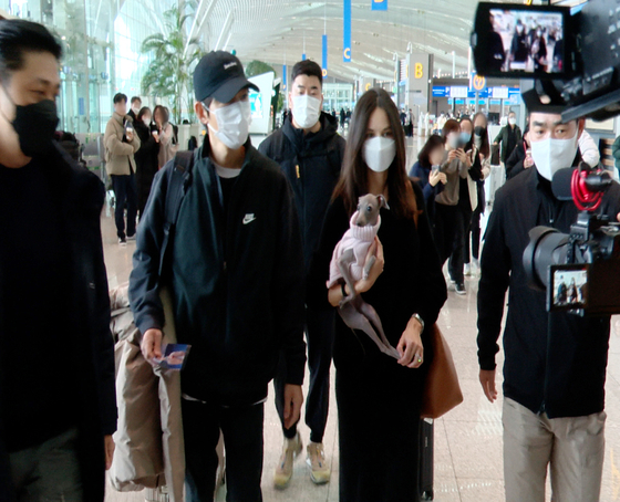 Actor Song Joong-ki and his wife Katy Louise Saunders leave for Hungary from Incheon International Airport on Thursday. Song is scheduled to begin filming for ″My Name Is Loh Kiwan,″ a new Netflix film set to be released later in the year. [NEWS1]