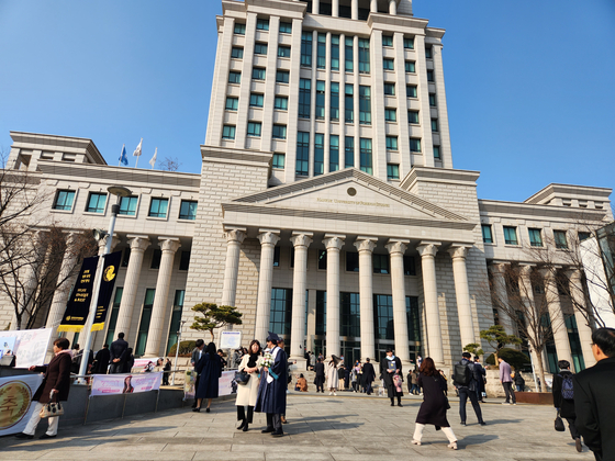 Students of Hankuk University of Foreign Studies' graduating class of 2023 take photos during its commencement ceremony on Feb. 17. [CHANG YOON-SEO]