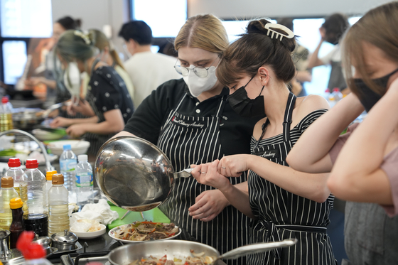 International students learn how to cook bulgogi (marinated beef) as part of Korea University’s summer school program, known as the Korea University International Summer Campus. [KOREA UNIVERSITY]