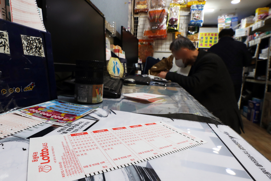 People purchase lottery tickets at a lottery store in Dongdaemun District, eastern Seoul, on Tuesday. [NEWS1]