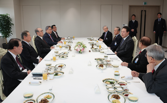 President Yoon Suk Yeol, center right, speaks at a luncheon meeting with doyens in Korea-Japan relations, including former Prime Minister Lee Hong-koo and former ambassadors to Japan, at the Yongsan presidential office in central Seoul Wednesday, ahead of his visit to Tokyo. [PRESIDENTIAL OFFICE]