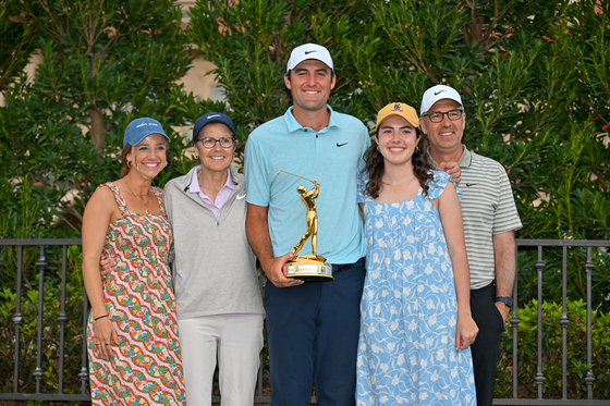 Scottie Scheffler poses for a photo with his wife Meredith and immediate family after winning during the trophy ceremony during the final round of The Players Championship at Stadium Course at TPC Sawgrass on Sunday in Ponte Vedra Beach, Florida. [GETTY IMAGES]