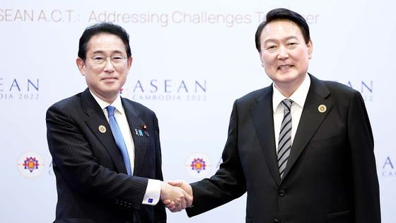 Korean President Yoon Suk Yeol, right, and Japanese Prime Minister Fumio Kishida shake hands prior to holding bilateral talks in Phnom Penh, Cambodia, on Nov. 13, 2022. [PRESIDENTIAL OFFICE]