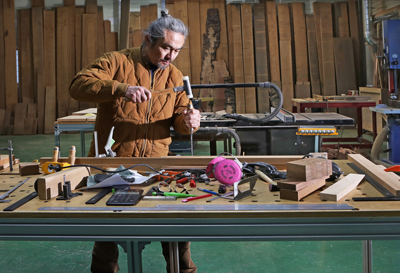 Carpenter Kim Yoon-kwan, who mainly creates furniture for a study, works at his workshop in Paju, Gyeonggi. [PARK SANG-MOON]