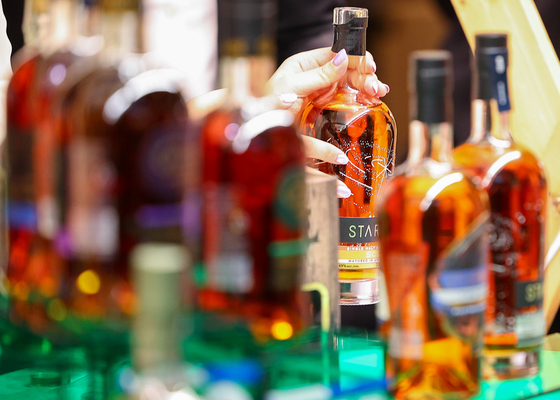 Customers shop for limited edition whiskeys at a Hyundai Department Store in Seongnam, Gyeonggi, on Wednesday. The department store opened a whiskey fair ″Whisky Eat″ as the distilled alcoholic beverage gains popularity among young Koreans. The amount of whiskeys sold this year through Monday increased 60 percent on year, announced Hyundai Department Store. [YONHAP]