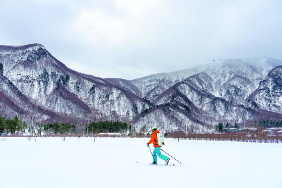 A traveler enjoys Nordic skiing across Nari Basin. [BAEK JONG-HYUN]