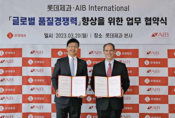 Lotte Confectionery President Lee Chang-yeop, left, and AIB International CEO Dan Martin sign a memorandum of understanding at Lotte Confectionery's headquarters in Yeongdeungpo District, western Seoul, on Monday. [LOTTE CONFECTIONERY]