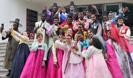 Diplomats from 25 countries dressed in hanbok take selfies in front of Kyung Hee University’s Institute of International Education in Dongdaemun, Seoul, Thursday. The diplomats attended a 12-week Korean language and culture program by the Korea Foundation that began on March 8. The attendees not only participated in various Korean cultural programs such as taekwondo and K-pop dancing, but also visited major Korean heritage sites including Gyeongbok Palace and the DMZ. [YONHAP]