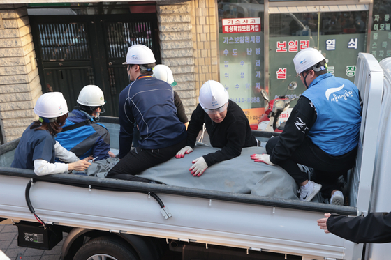 Sero the zebra heads back to the zoo, covered in a blanket and held down by six officials on a truck. [YONHAP]