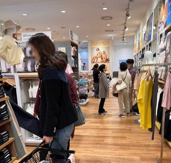 People shop at a Uniqlo store in Seoul on March 15. [SOHN DONG-JOO]