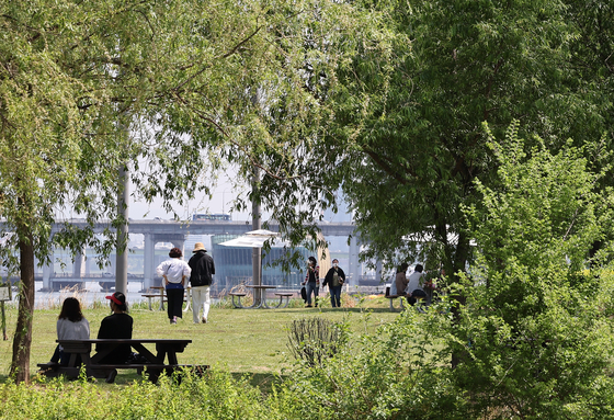 People spend their afternoons resting in the sun at Banpo Hangang Park. [YONHAP]