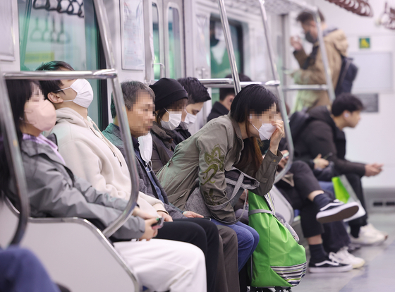 Most passengers wear masks on a metro in Seoul on March 20. [YONHAP]