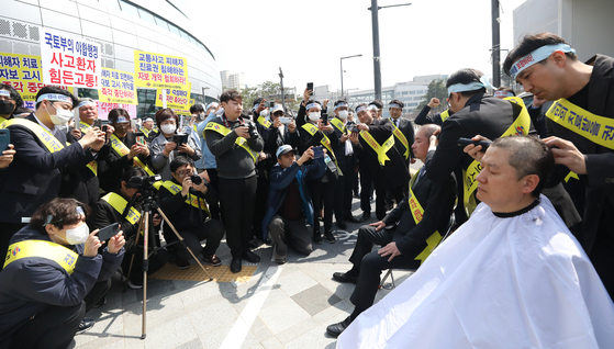 Members of the Association of Korean Medicine shave their heads in a protest in front of the building of Ministry of Land, Infrastructure and Transport in Sejong on March 29. The ministry is planning to revise the policy for herbal medical clinics to reduce the prescription period from 10 days to five for patients from car accidents, and file details about their medial bills to their insurance companies. [NEWS1] 