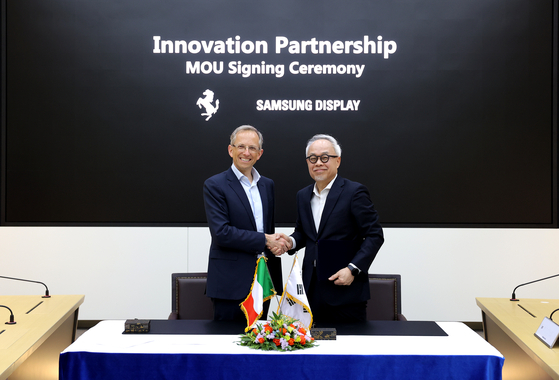 Benedetto Vigna, left, Ferrari CEO, and Samsung Display CEO Choi Joo-sun pose for a photo during a signing ceremony held at the Samsung Display's Asan plant in South Chungcheong on Tuesday. [SAMSUNG DISPLAY]
