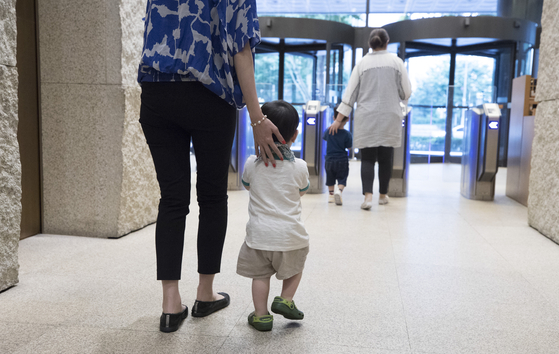An image of a mother and her son leaving a building in central Seoul [YONHAP]
