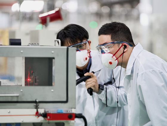 LG Corporation Chairman Koo Kwang-mo, right, inspects a cathode production facility at LG Chem's plant in Cheongju, North Chungcheong, on Monday. [LG CHEM]
