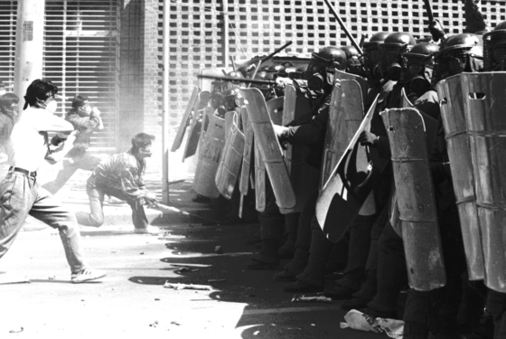 Students clash with soldiers at the front gates of Chonnam National University on May 18, 1980, at the start of the Gwangju Uprising. [JOONGANG ILBO]