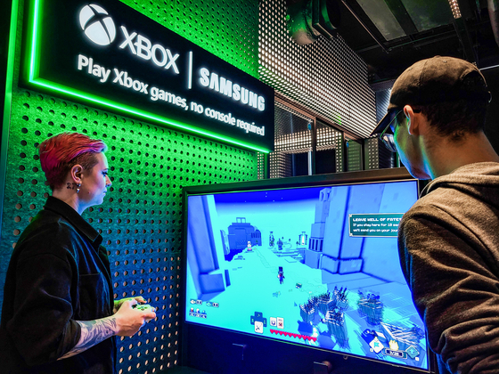 A Samsung Electronics employee plays a game using the company's smart TV and gaming monitor in the Gaming Hub experience zone at the Microsoft Experience Center (MEC) in London. The center is a gaming hub jointly opened by Samsung Electronics and Microsoft. Another center is also located in New York City. [YONHAP]