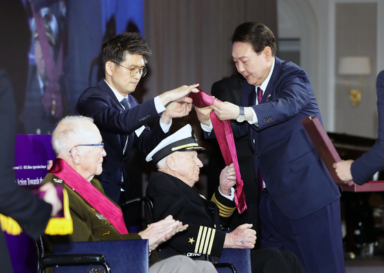 President Yoon Suk Yeol (R) confers the Taegeuk Order of Military Merit on retired Navy Capt. Elmer Royce Williams during a luncheon celebrating the 70th anniversary of the Korea-U.S. alliance at a hotel in Washington on Tuesday. [YONHAP]