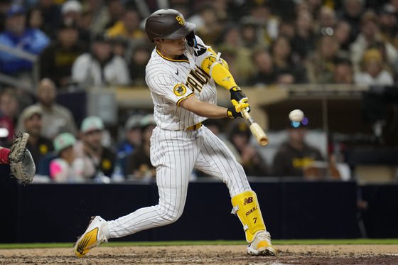 San Diego Padres' Kim Ha-seong hits a three-run home run during the fifth inning of a game against the Cincinnati Reds at Petco Park in San Diego on Monday. Kim's long ball broke a 3-3 tie, leading the Padres to a big 8-3 win.  [AP/YONHAP]