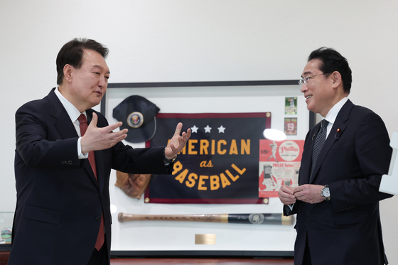 President Yoon Suk Yeol, left, shows Japanese Prime Minister Fumio Kishida the gift he received from U.S. President Joe Biden during his visit to Washington last week on Sunday night. Yoon and Kishida had a private dinner at the presidential residence in Hannam-dong. [PRESIDENTIAL OFFICE]