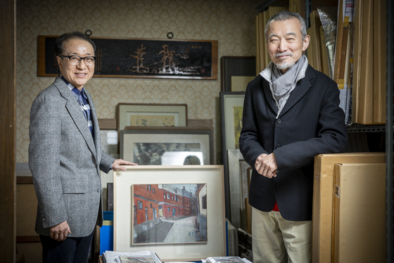 Art collectors Kim Tae-sup, left, and Yoon Young-ju stand with artist Won Guei-hong's paintings at Kim's house, which was once Won's house. [JOONGANG SUNDAY] 