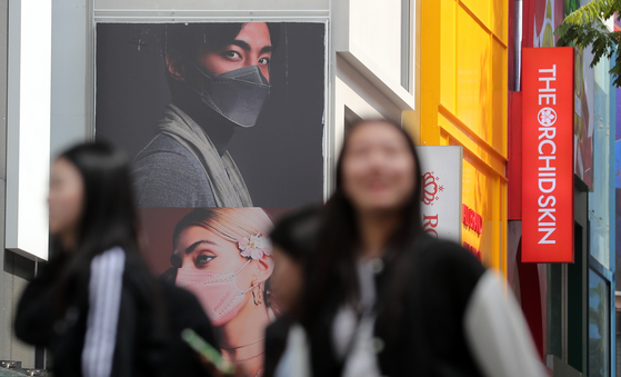 People roam the streets of Myeong-dong maskless on Wednesday. [NEWS1]