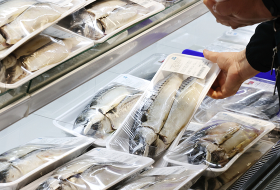A person shops for fish products at a discount store in downtown Seoul in March. [YONHAP]