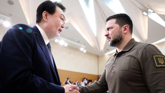 Korean President Yoon Suk Yeol, left, shakes hands with Ukrainian President Volodymyr Zelensky at the G7 Summit in Hiroshima, Japan, Sunday. [JOINT PRESS CORPS]