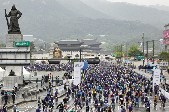 Cyclists ride along Gwanghwamun with Gyeongbok Palace as a backdrop in downtown Seoul on Sunday. The Seoul Bike Festival is the country's biggest bicycle event, hosted by the JoongAng Ilbo and JTBC and sponsored by Seoul's city government. The cyclists began riding at 8 a.m. and traveled 21 kilometers (13 miles), including a stretch along Gangbyeon Expressway, before finishing at World Cup Park in Mapo District, western Seoul. [JUN MIN-KYU] 