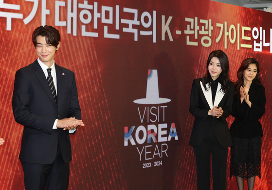 First lady Kim Keon-hee, center, attends the launching ceremony of a K-tour cooperative group to promote the Korean tourism industry at the Korea Tourism Organization's HiKR Ground publicity center in Jung District, central Seoul, on Tuesday. Kim is joined by Lee Boo-jin, right, head of Hotel Shilla and chairperson of the Visit Korea Committee, and singer and actor Cha Eun-woo, left, the committee's promotional ambassador, on the stage. The cooperative group consists of 80 companies and agencies in the tourism sector and offers joint promotion events to inbound tourists, such as a streamlined verification and payment process for public transportation. [YONHAP]