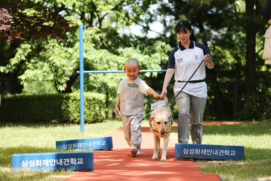 A young monk of Jogyesa Temple embark on a short excursion alongside guide dogs at Samsung Fire & Marine Insurance Guide Dog School in Yongin, Gyeonggi Province on Tuesday. [YONHAP]