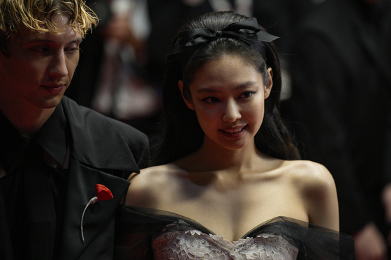 Troye Sivan, left, and Jennie of girl group Blackpink pose for photographers upon arrival at the premiere of the television series ″The Idol″ at the 76th Cannes International Film Festival on Tuesday. [EPA]