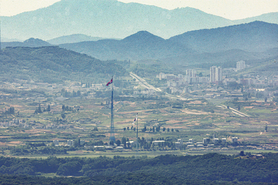 A South and North Korean flag are hoisted in adjacent villages near the demilitarized zone in Paju, Gyeonggi, on Monday. [YONHAP]