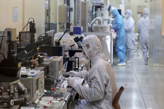A researcher conducts a study at a semiconductor laboratory of the Electronics and Telecommunications Research Institute (ETRI) in Daejeon on Thursday. The Ministry of Science and ICT held a signing ceremony that day with ETRI, Seoul National University and two more participants, for a program that enables undergraduates and graduate students to produce and test semiconductors they have designed by themselves. [YONHAP]  