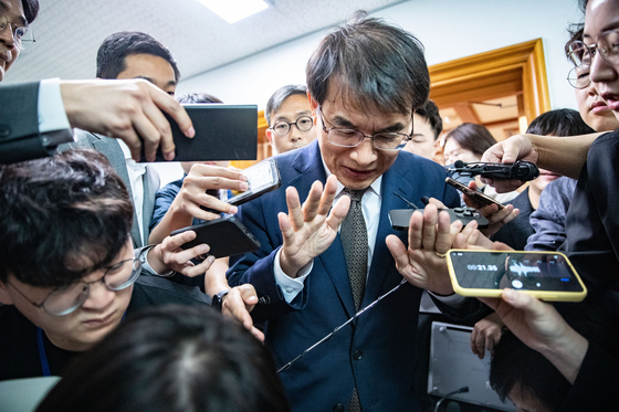 Rho Tae-ak, center, chairman of the National Election Commission (NEC), is surrounded by reporters after leaving a meeting of the NEC at the agency's headquarters in Gwacheon, Gyeonggi, Friday. [NEWS1]
