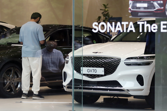 A consumer browses cars at a Hyundai Motor dealership in central Seoul on Thursday, the day that the government announced an end of special tax cuts on car purchases. [NEWS1]