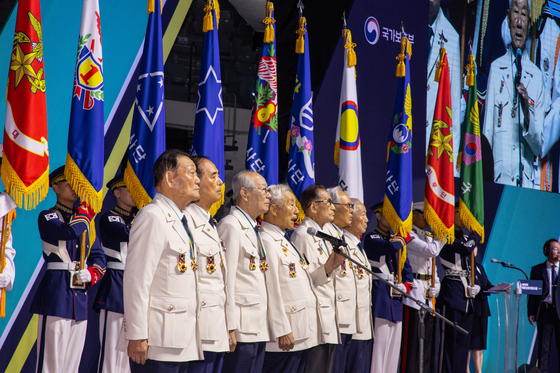 Veterans of the 1950-53 Korean War read a statement together at the ceremony to commemorate the 73rd anniversary of the outbreak of the war at the Jangchung Gymnasium in Seoul on Sunday. The veterans are wearing uniforms specially designed for them by the Ministry of Patriots and Veterans Affairs. [YONHAP]